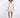 A model poses in a light beige button-up top and matching shorts, complemented by black open-toe heels.