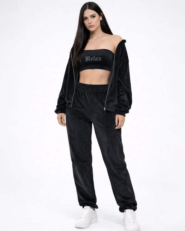 Model in Carbon 3-piece tracksuit set with a 'Relax' tube top, zip-up hoodie, and joggers for urban streetwear.