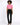 A model poses in a cropped pink top with buttons and pockets, paired with black tailored pants and heels.