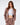 A model poses in a fitted, light brown blazer and matching trousers over a white crop top, showcasing a stylish look.