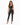 A model poses in a fitted black ribbed crop top and matching high-waisted pants with side slits.