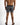 Back view of Niko men's vertical black and white striped swimsuit with black waistband and back pocket.