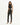 A model poses in a fitted black crop top and high-waisted pants with side slits, showcasing a sleek silhouette.