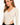 A model poses in a beige ribbed bodysuit featuring a deep V-neck and cut-out sides, styled with black pants.