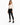 A model poses in a fitted long-sleeve top with a cutout design, paired with black skinny jeans and sneakers.