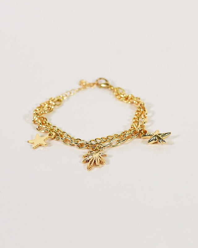 Golden minimalist chain anklet featuring a double chain with palm tree, star, and starfish charms on a white background.