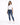 A woman stands confidently in a casual white t-shirt and distressed blue jeans, paired with white sneakers.