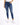 A person wearing fitted blue jeans with distressed knee details and white sneakers, standing against a plain background.