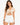 A model wearing a beige cropped top with a V-neck and drawstring detail, paired with white denim shorts.