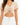 A cropped beige top with a V-neck and gathered front detail, featuring a tie closure at the waist.