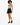A model poses in a patterned bodysuit and high-waisted black shorts, paired with black sneakers.
