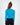 Back view of woman wearing the Goldie Top, a blue long-sleeve ribbed knit crop top paired with dark-wash jeans.