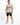 A man stands confidently in a sleeveless gray top featuring colorful graffiti-style text, paired with distressed blac...