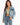 A woman poses in a light blue denim jacket over a fitted green top, paired with high-waisted blue jeans.