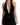 A woman models a sleek black halter dress featuring a deep V-neckline and side ruching.