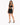 A model poses in a black cropped top with lace-up details and a matching skirt featuring side ties.