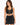 A model poses in a black cropped top with lace-up detailing and a matching skirt featuring side ties.