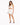 A model poses in a white lace-up crop top and matching mini skirt, complemented by black high-heeled sandals.
