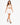 A model walks confidently in a white lace-up crop top and matching skirt with side ties and black heels.