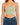 Light green cropped top with thin straps, paired with high-waisted blue denim jeans.