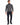 A man stands confidently in a fitted gray turtleneck sweater paired with dark trousers and black sneakers.