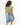 Back view of Gravity Grey padded muscle tee with structured shoulders and raw-hem denim shorts for a streetwear aesthetic.