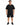 A man stands wearing a loose-fitting black t-shirt with a graphic design, paired with black shorts and sneakers.