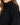 Close-up of a woman wearing a black sweatshirt with a high collar, showcasing fabric texture.