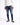 A person wearing a white hoodie, distressed blue jeans, and black sneakers stands against a plain background.