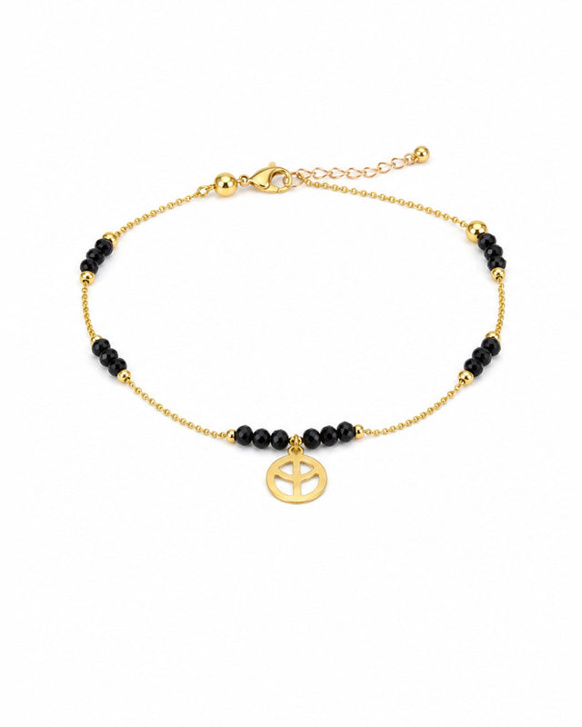 Gold bracelet featuring black beads and a peace symbol charm, ideal for casual or bohemian styles.