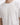 White t-shirt featuring a textured, embossed "PEACE" design on the front, worn by a model.