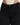 Close-up of a fitted black denim bottom with a high waist, paired with a ribbed beige top.