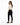 A woman with long hair poses in a fitted beige top and black skinny jeans, showcasing a stylish back cutout.