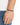 A hand wearing a colorful bead bracelet on a black cord, set against a light background.
