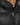 Close-up of a black puffer coat featuring a high collar and a silver zipper, showcasing its sleek design.