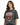 A woman with wavy hair wears a faded black t-shirt featuring an eagle graphic and bold text design.