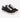 Black canvas sneakers with white laces and a textured finish, featuring a low-profile design and rubber sole.