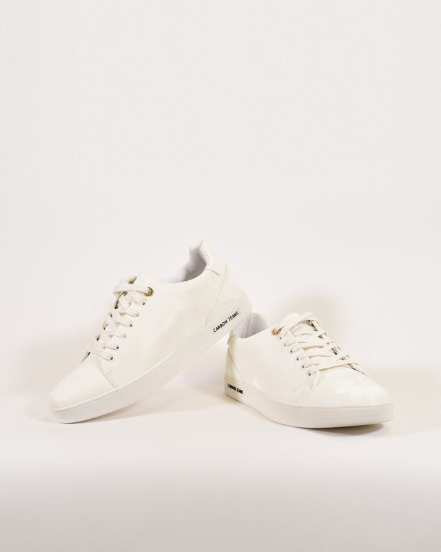 A pair of glossy white sneakers with lace-up design and subtle branding on the side.