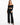 A model wearing black wide-leg pants paired with a cropped off-the-shoulder top and strappy heels.