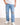 Light blue distressed jeans with ripped knees, paired with a white t-shirt and white sneakers.