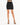 A fitted black skirt paired with strappy black heels, showcasing a sleek silhouette and modern style.