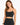 A woman with long hair wears a fitted black crop top with thin straps, showcasing a stylish and casual look.