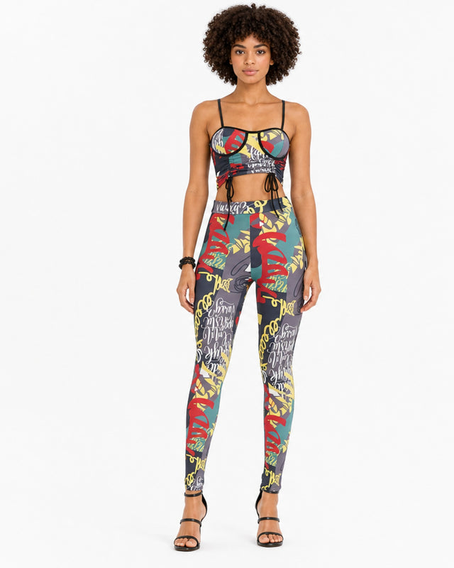 A model showcases a colorful two-piece set featuring a cropped top and fitted leggings with vibrant patterns.