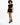 A model poses in a black cropped top and stylish black shorts with unique cut-out details, paired with combat boots.