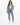 A model wearing light blue jeans with a cropped top and denim jacket, paired with white sneakers.