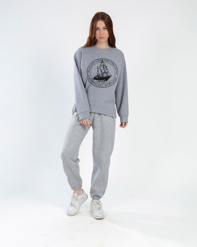 Model wearing a light grey oversized Sailing Top with a black vintage ship graphic and matching joggers.