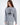 Woman in an oversized light grey Sailing Top with a black circular ship graphic, a modern streetwear essential.