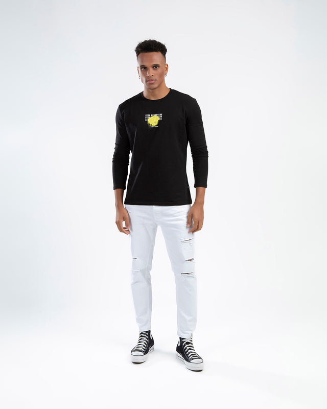 Model wearing Keep On Moving black graphic long sleeve streetwear shirt with white distressed jeans.
