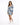 A woman poses in a fitted dress with puffed sleeves and a blue tropical print, paired with white sneakers.