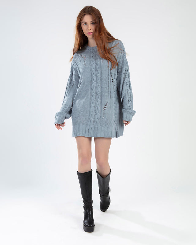Model wearing the Saylor Sweater, a light blue oversized distressed cable knit pullover on a white background.